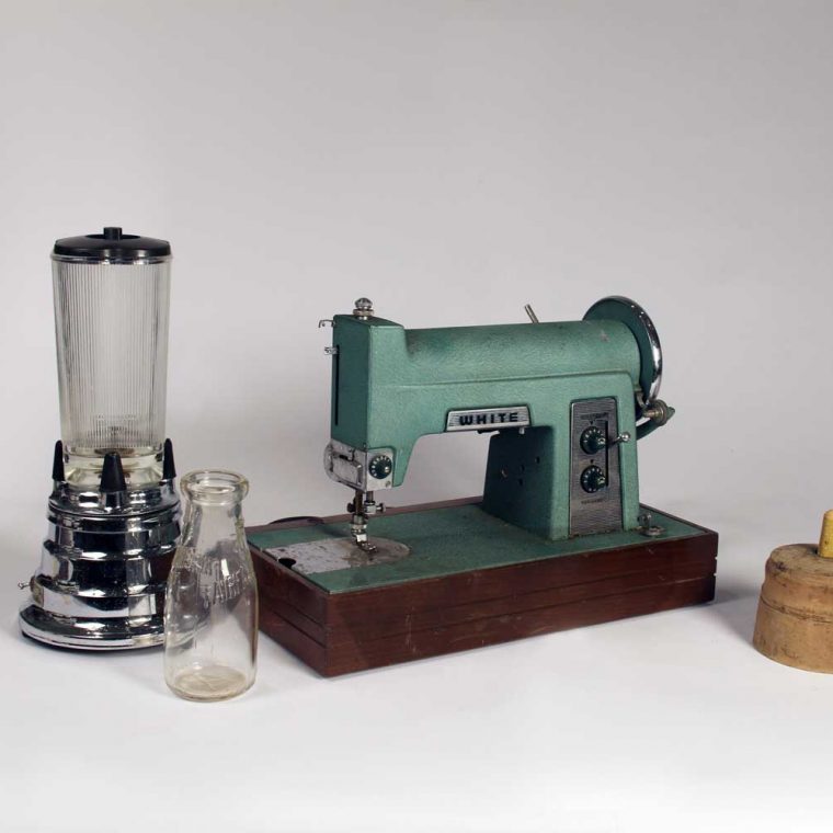 Waring Blender, 1947; Milk bottle, mid-20th century; Sewing Machine, late 19th century; Butter mold, 1920s. Photo by Museum staff. 