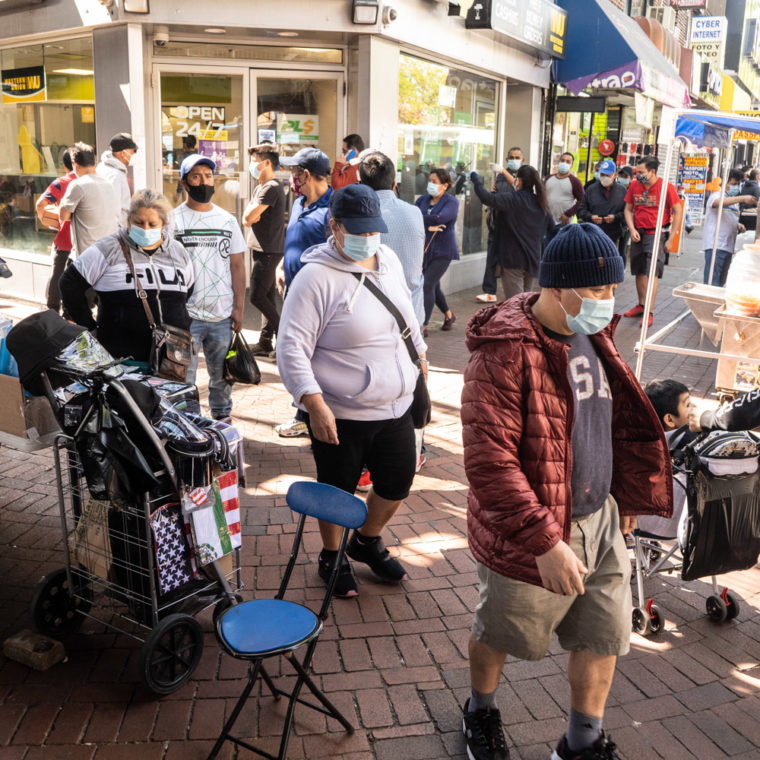 May 17, 2020: Everybody is wearing a mask outside a PLS Check Cashers storefront at the corner of Roosevelt Avenue and Junction Boulevard in Queens, New York. © Camilo José Vergara 